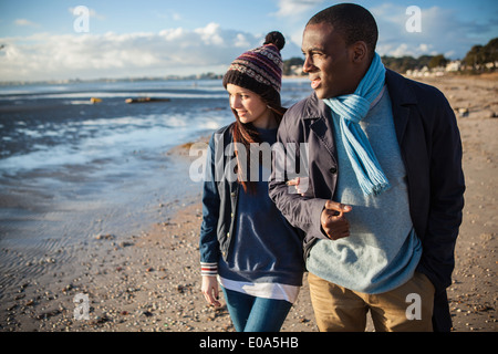 Romantic young couple arm in arm on the beach Stock Photo