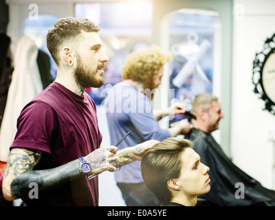 Barber styling young mans hair Stock Photo