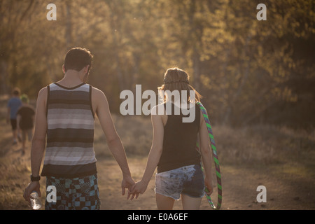 Young couple walking in forest holding hands Stock Photo