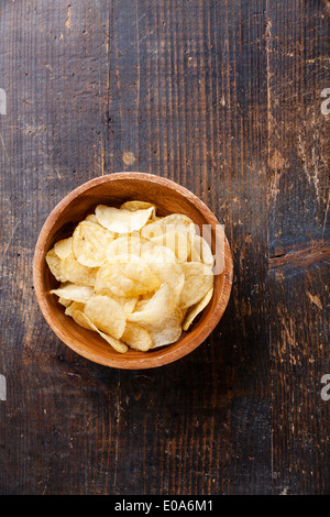 Crispy potato chips on wooden background Stock Photo