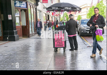 Donegall Place, Belfast, UK. 7th May 2014. Belfast Telegraph newspaper vendor with placard reading 'All the Latest Giro D'Italia coverage' Credit:  J Orr/Alamy Live News Stock Photo