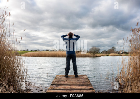Desperation young man with hand in hair on the edge of a dock Stock Photo