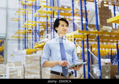 Male manager using digital tablet in distribution warehouse Stock Photo