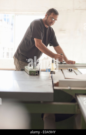 Upholsterer preparing planks on miter saw Stock Photo