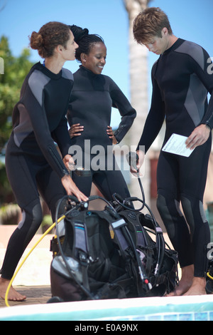 Scuba diving instructor and pupils with scuba tanks Stock Photo