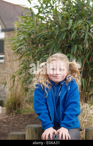 Portrait of schoolgirl sitting in garden Stock Photo