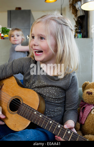 Young girl playing acoustic guitar Stock Photo