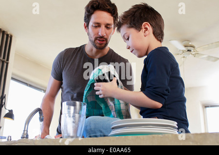 Father and son doing washing up chores Stock Photo
