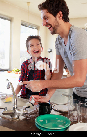 Father and son with soap suds on hands Stock Photo