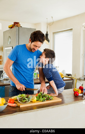 Father and young son preparing vegetables in kitchen