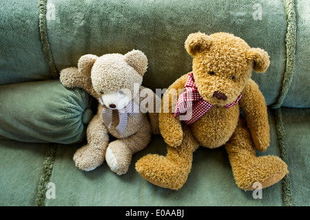 Two teddy bears sitting on sofa Stock Photo
