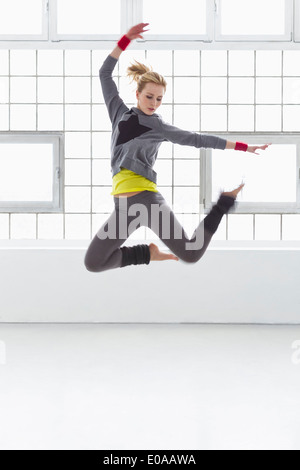 Young woman jumping in gymnasium Stock Photo