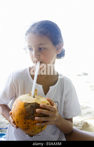 Girl drinking from a coconut Stock Photo