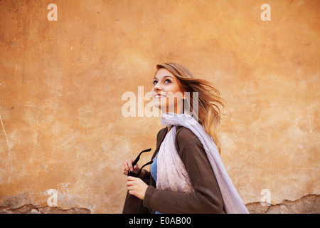Young woman strolling down street looking sideways Stock Photo