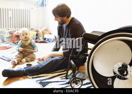 Disabled father with son playing on floor Stock Photo