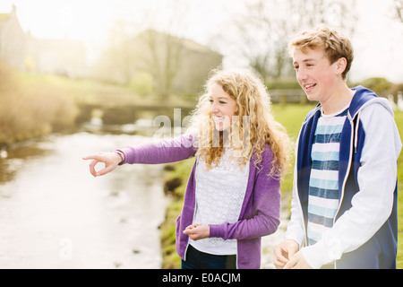 Teenage brother and sister on rural riverbank Stock Photo