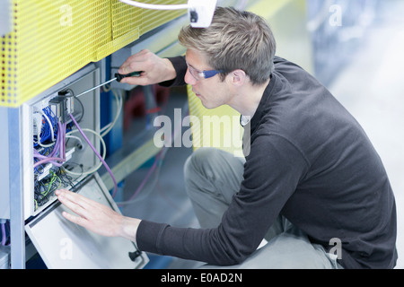 Mid adult male technician maintaining equipment in engineering plant Stock Photo