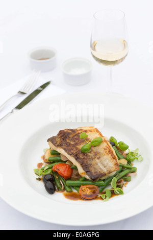 Pan fried fish on a bed of vegetables.