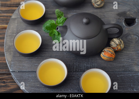 Green tea in cups with mint and teapot on wooden background Stock Photo