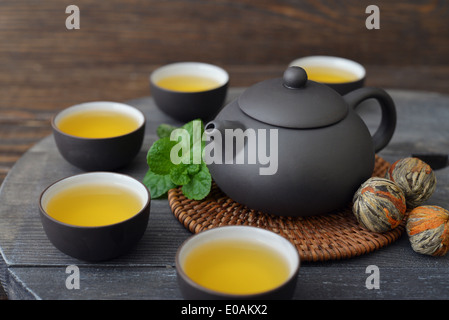Green tea in cups with mint and teapot on wooden background Stock Photo