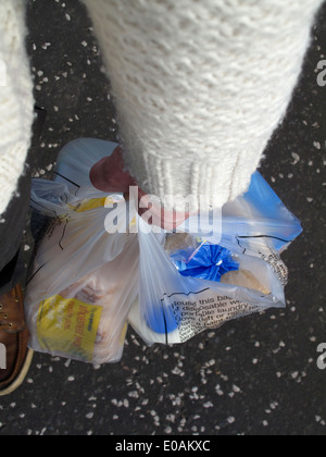 Arm and hand holding shopping bags of food Stock Photo
