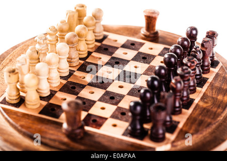 a small wooden chess board with chess pieces isolated over white Stock Photo