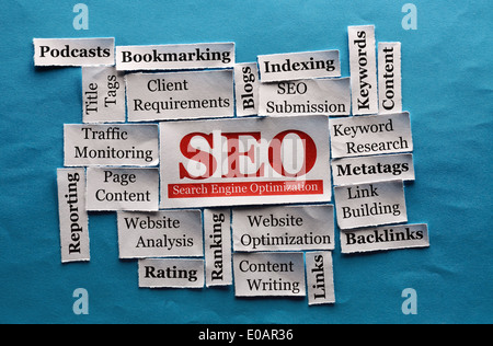 SEO Word Cloud printed on paper on blue font Stock Photo