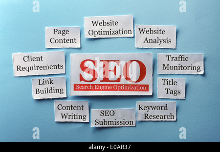SEO Word Cloud printed on paper on blue font Stock Photo