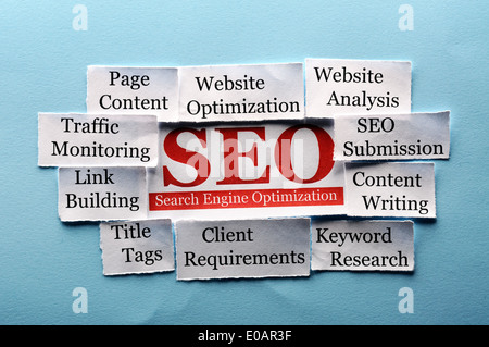 SEO Word Cloud printed on paper on blue font Stock Photo