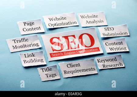 SEO Word Cloud printed on paper on blue font Stock Photo