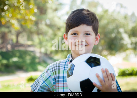 Cute Young Boy Playing with Soccer Ball Outdoors in the Park. Stock Photo