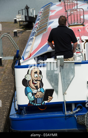 Shakespeare using a tablet cartoon on the rear of a Canal River Tour Barge in the lock at Stratford Upon Avon, England Stock Photo