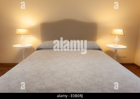 a big and cozy bed in a rustic hotel room Stock Photo