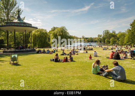 Young people relaxing next to the Band stand in the summer sunshine, Regents Park London England UK Stock Photo