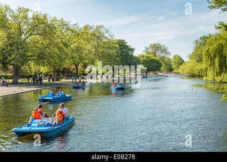 A hot London summer day with pedalo boats cruising on the lake in Regents Park London England UK Stock Photo