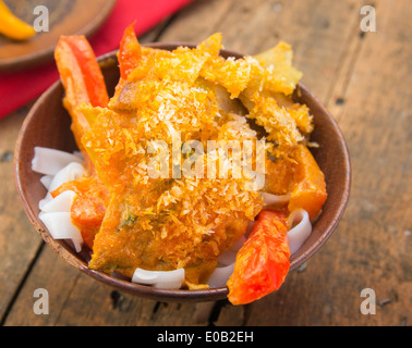 Asian rice noodles with red vegetables in wooden bowl on old ground Stock Photo