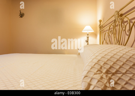 a luxurious bedroom with a lamp over a bed side table Stock Photo
