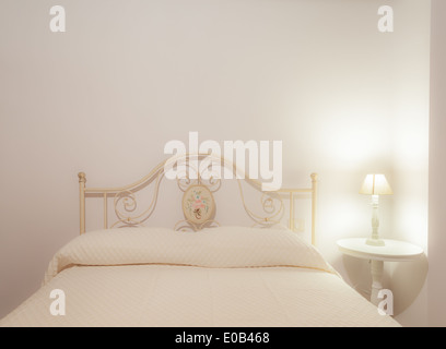 a luxurious bedroom with a lamp over a bed side table Stock Photo