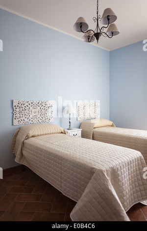 a luxurious bedroom with a lamp over a bed side table Stock Photo