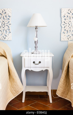 a luxurious bedroom with a lamp over a bed side table Stock Photo