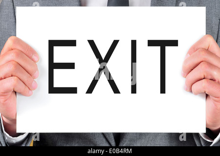 man wearing a suit holding a signboard with the word exit written in it Stock Photo