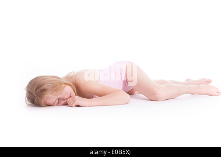 young blond girl sleeping on the floor of studio against white background Stock Photo