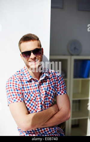 Young guy in sunglasses smiling and looking at camera Stock Photo
