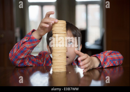 Boy stacking up biscuits Stock Photo