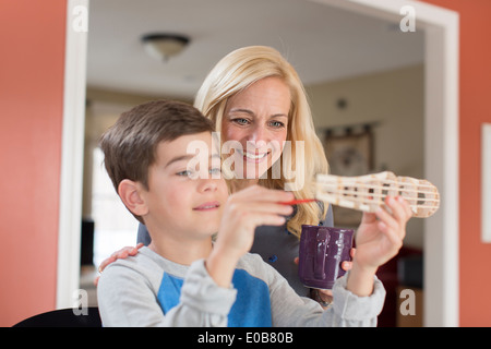 Mother admiring sons hand made model Stock Photo