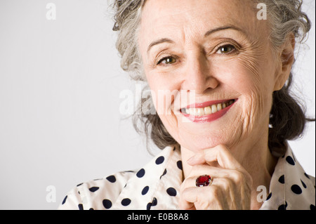 Portrait of senior woman, hand on chin, smiling