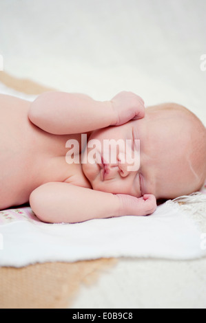 Baby asleep with hands beside face Stock Photo
