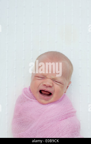 Baby crying, wrapped in blanket Stock Photo