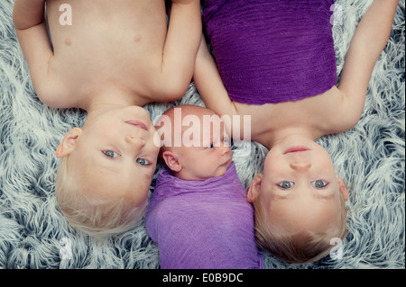 Siblings lying on carpet Stock Photo
