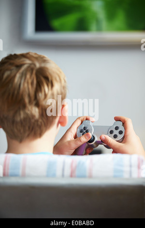 Rear View Of Boy Holding Controller Playing Video Game Stock Photo
